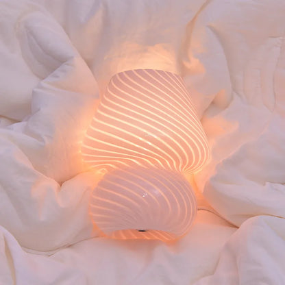 Glass LED Desk Lamp spiral texture switched on while lying on a duvet